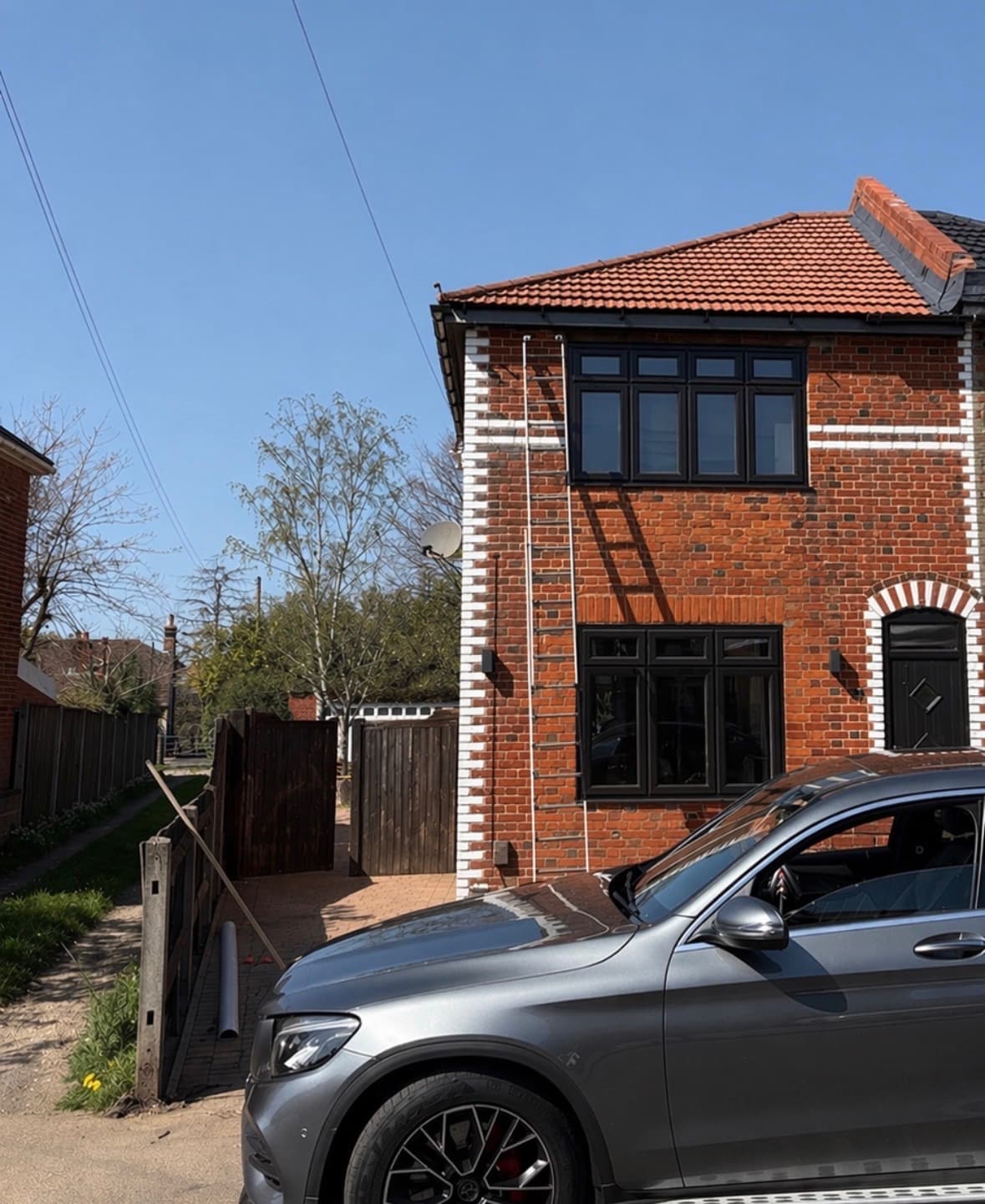 Dark grey UPVC sash windows on red brick property after spraying