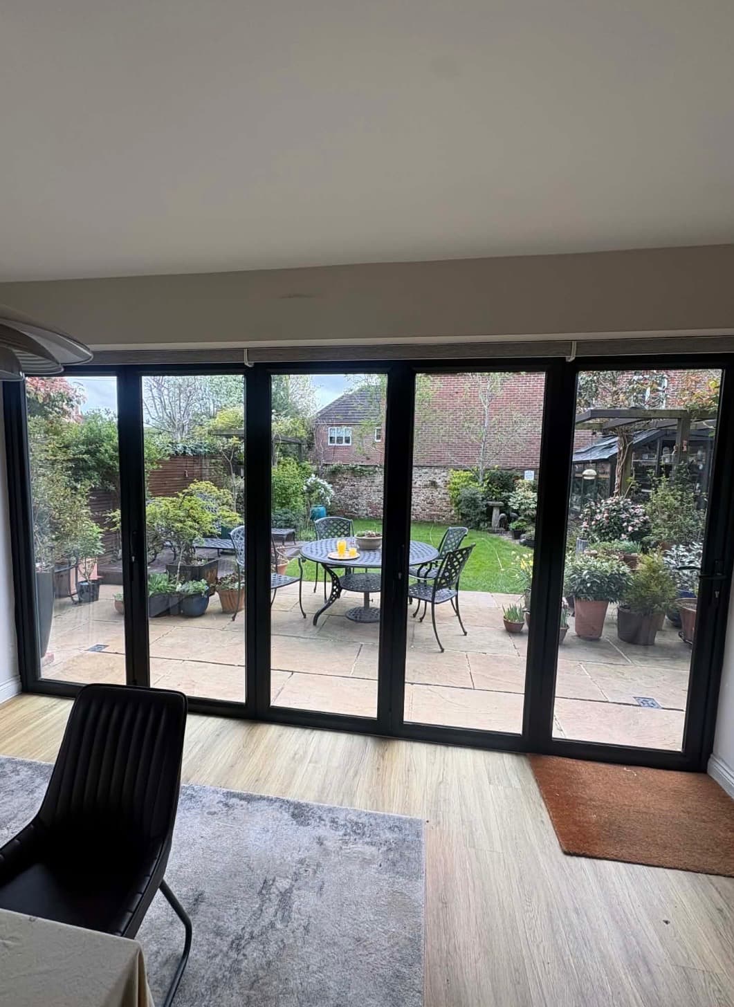 Black sprayed UPVC bifold doors looking out onto a garden patio